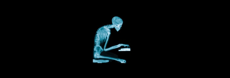 Image of a side view of an x-ray skeleton figure sitting at a desk working at a keyboard.